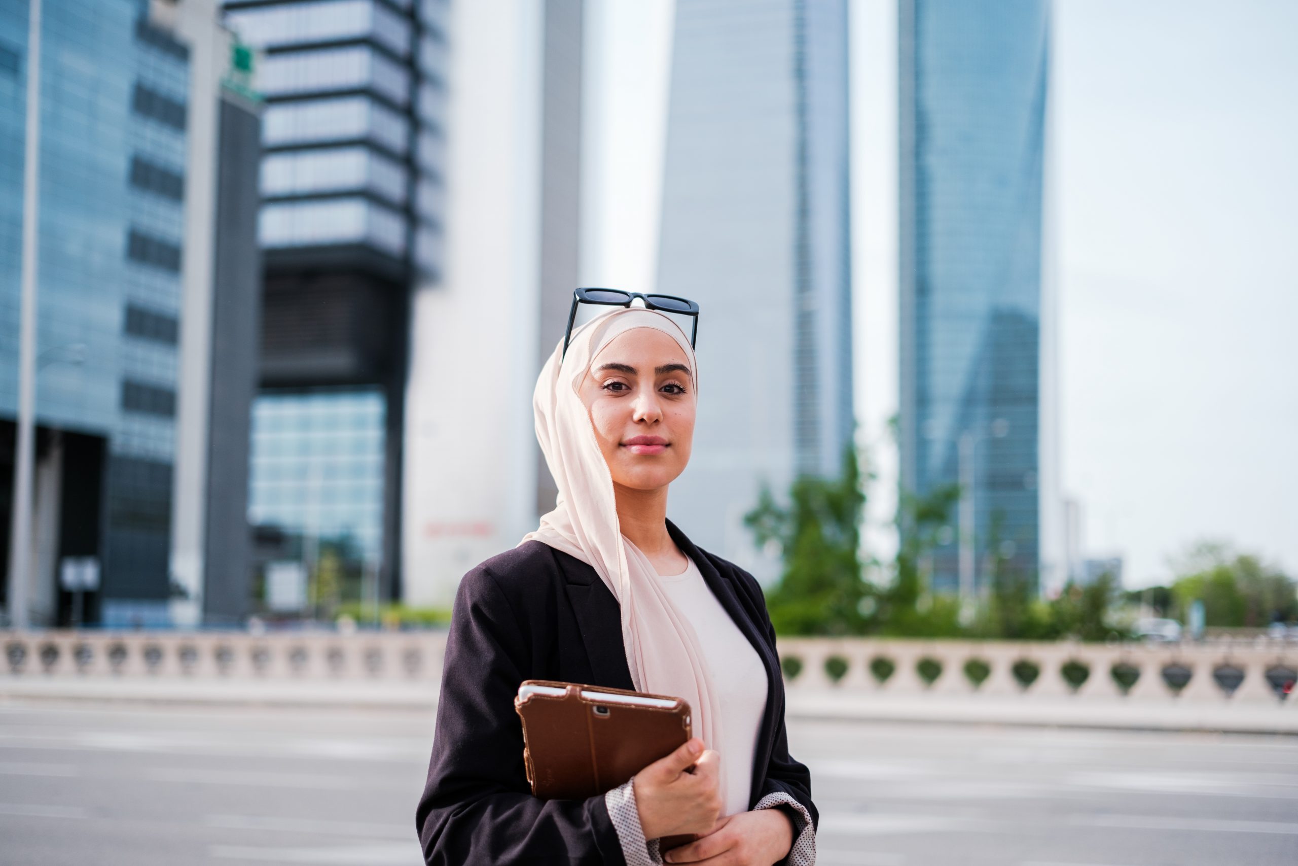 Corporate portrait of young businesswoman with hijab in business area